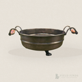 A small dark brass bowl with two looped side handles and decorative claw-like feet, shown on a plain light beige background. A Field Finds watermark appears in the lower right corner.