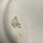 Antique White Ironstone Platter. Close-up of the back of the platter, showing a dark printed royal monogram logo and a small orange-brown stain near the bottom.
