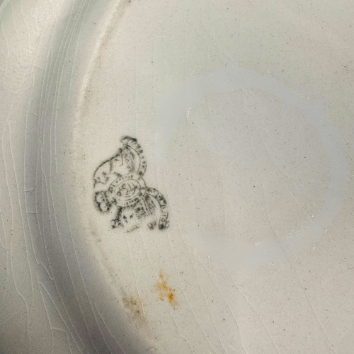 Antique White Ironstone Platter. Close-up of the back of the platter, showing a dark printed royal monogram logo and a small orange-brown stain near the bottom.