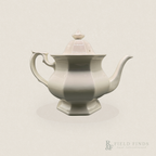 English Ironstone Teapot & Sugar Bowl — W.T. Adams & Sons. A white ironstone teapot with a lid, featuring a flared base, hexagonal form, and a curved handle, shown against a solid light beige background with a faint shadow.