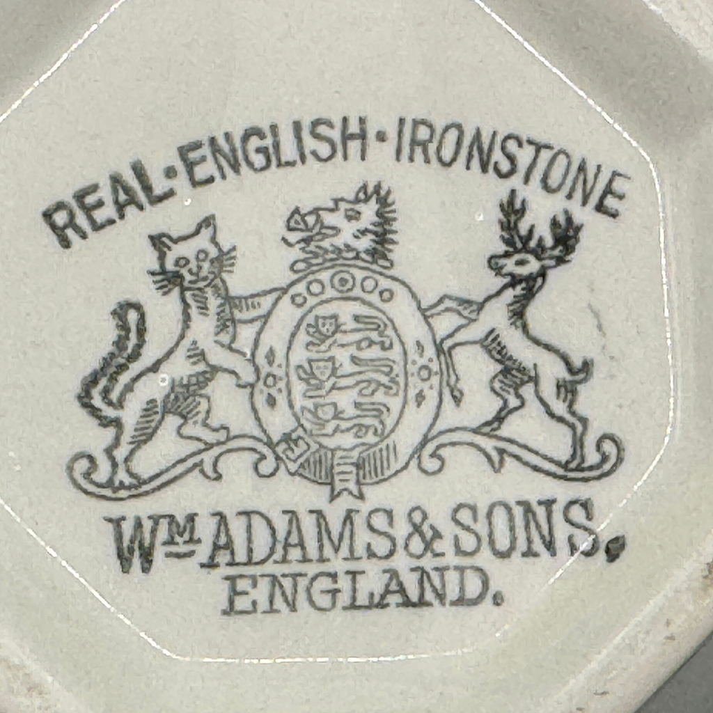 English Ironstone Teapot & Sugar Bowl — W.T. Adams & Sons. Close-up of the maker's mark printed with the text 'REAL ENGLISH IRONSTONE' and 'WM. ADAMS & SONS ENGLAND' around a crest featuring a cat, deer, and lion.